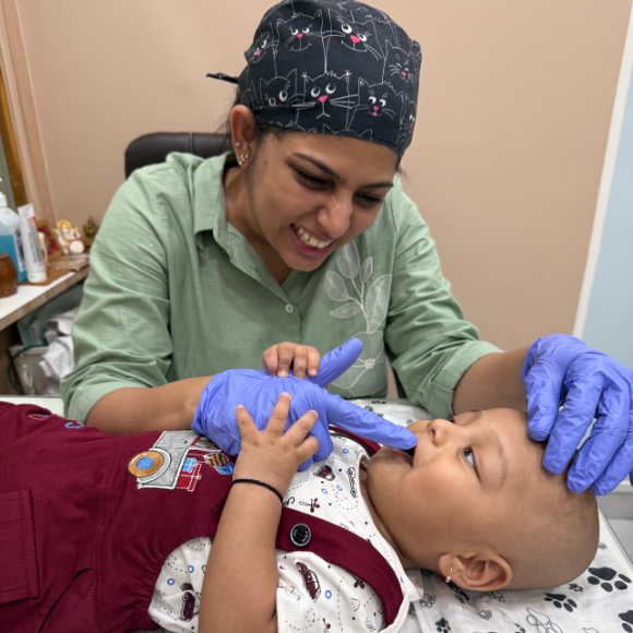 Dr Anushree Khatri, Best pediatric dentist in Nagpur, examining infant’s mouth for tongue or lip tie: early diagnosis for better feeding and oral development.